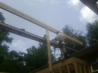 Carpenter setting a ridge beam over a new addition frame — Ice Dam Removal by Roofing Brothers in Rye