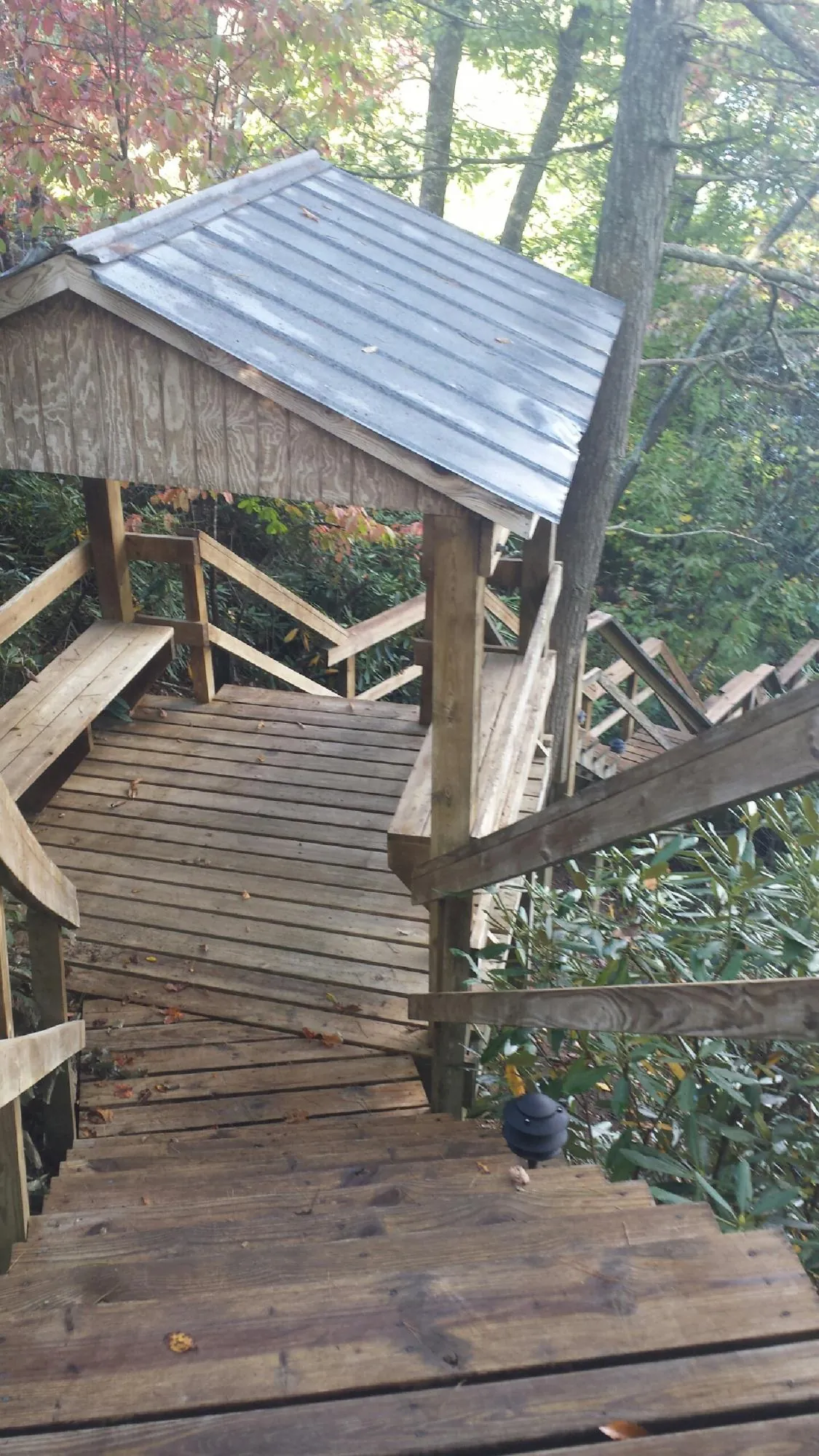 Metal roofed shelter over wooden steps on a wooded walkway — Skylight Repair & Installation work by our crew in Rye