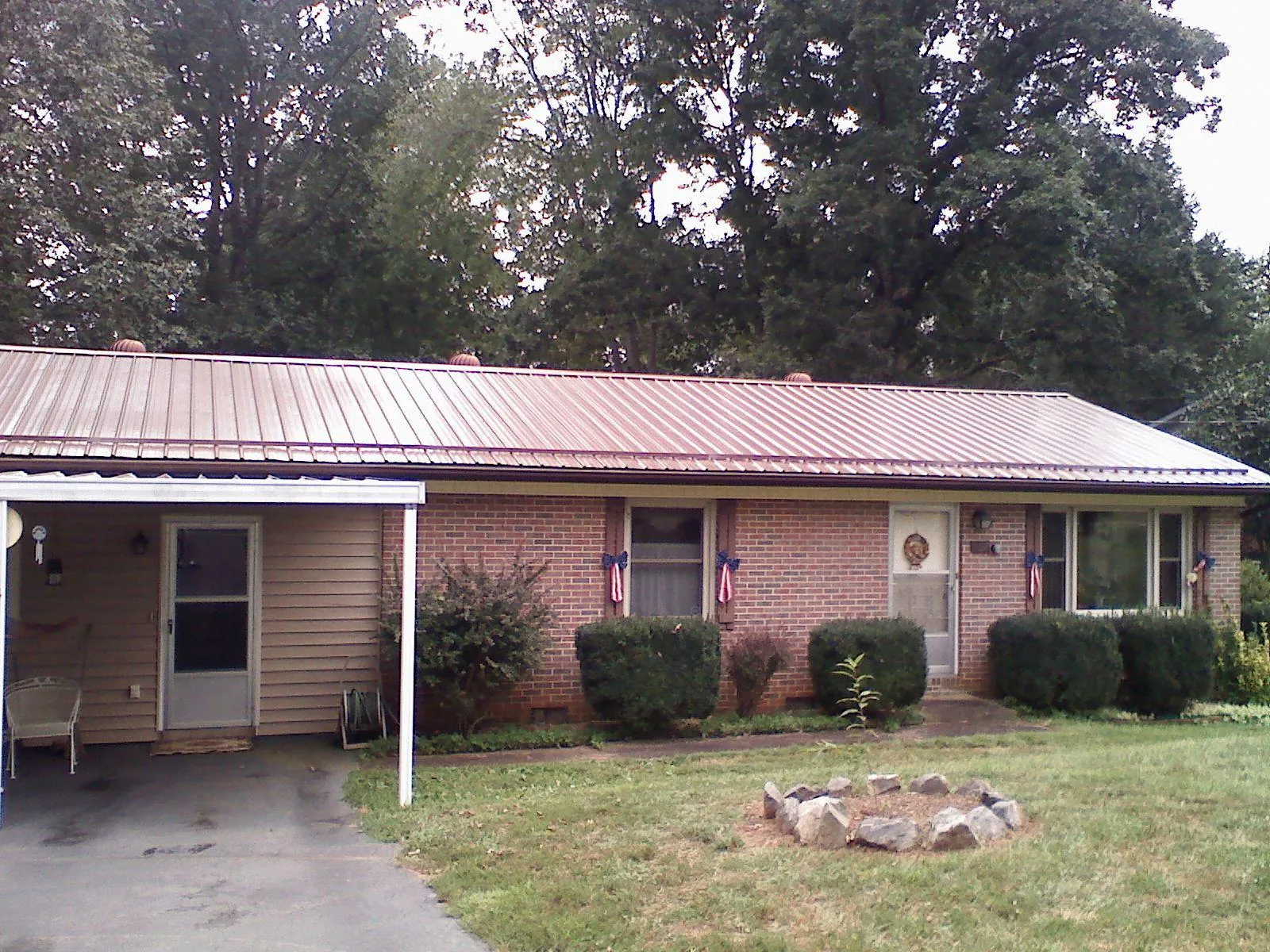 Bronze metal roof and carport on a brick ranch home — Roof Repair work by our crew in Rye